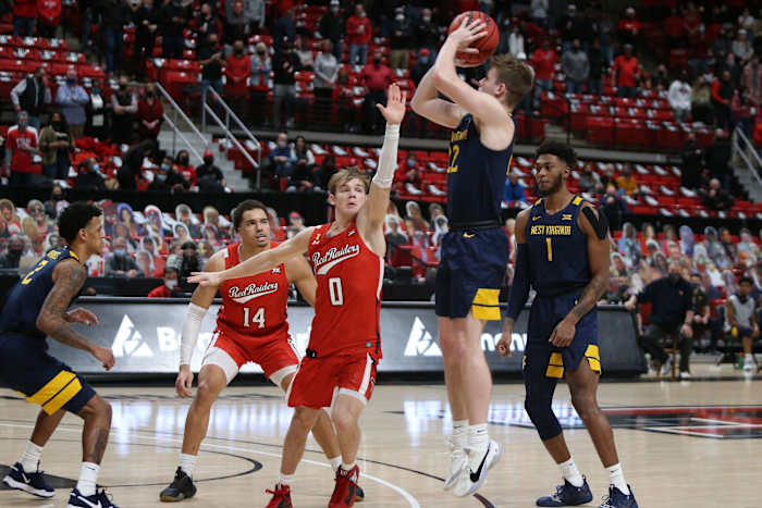 Feb 9, 2021; Lubbock, Texas, USA; West Virginia Mountaineers guard Sean McNeil (22) shoots over Texas Tech Red Raiders guard Mac McClung (0) in the first half at United Supermarkets Arena.